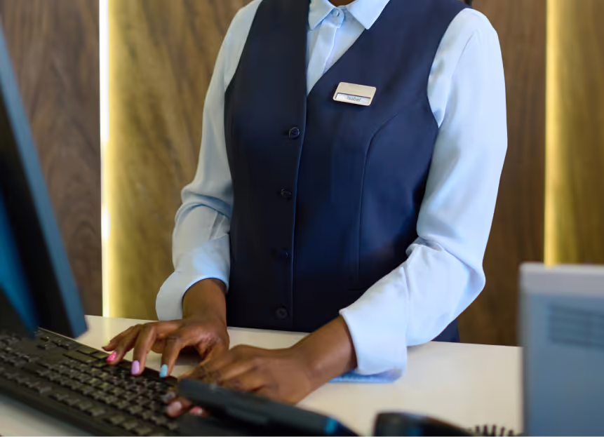 A receptionist at a hotel typing on a keyboard